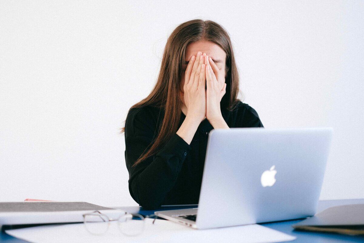 Erschöpfte Frau arbeitet am Laptop