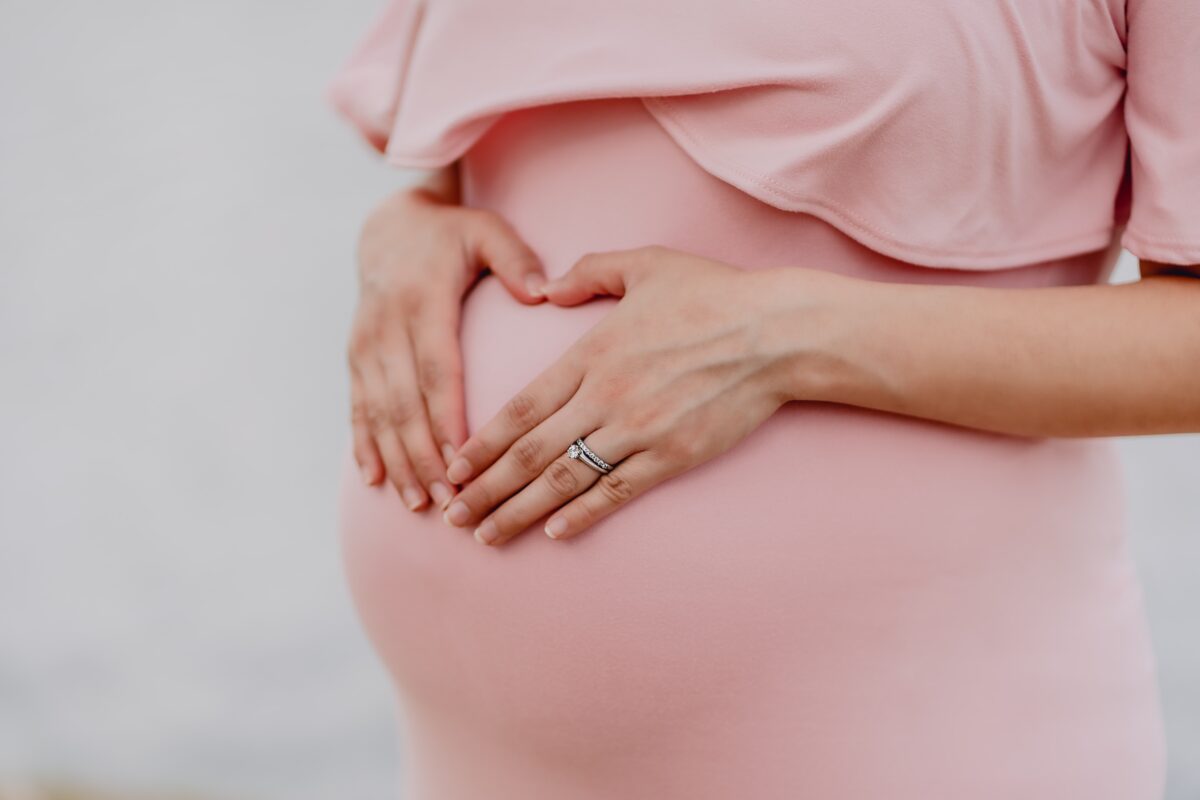 Schwangere Frau mit Händen am Bauch