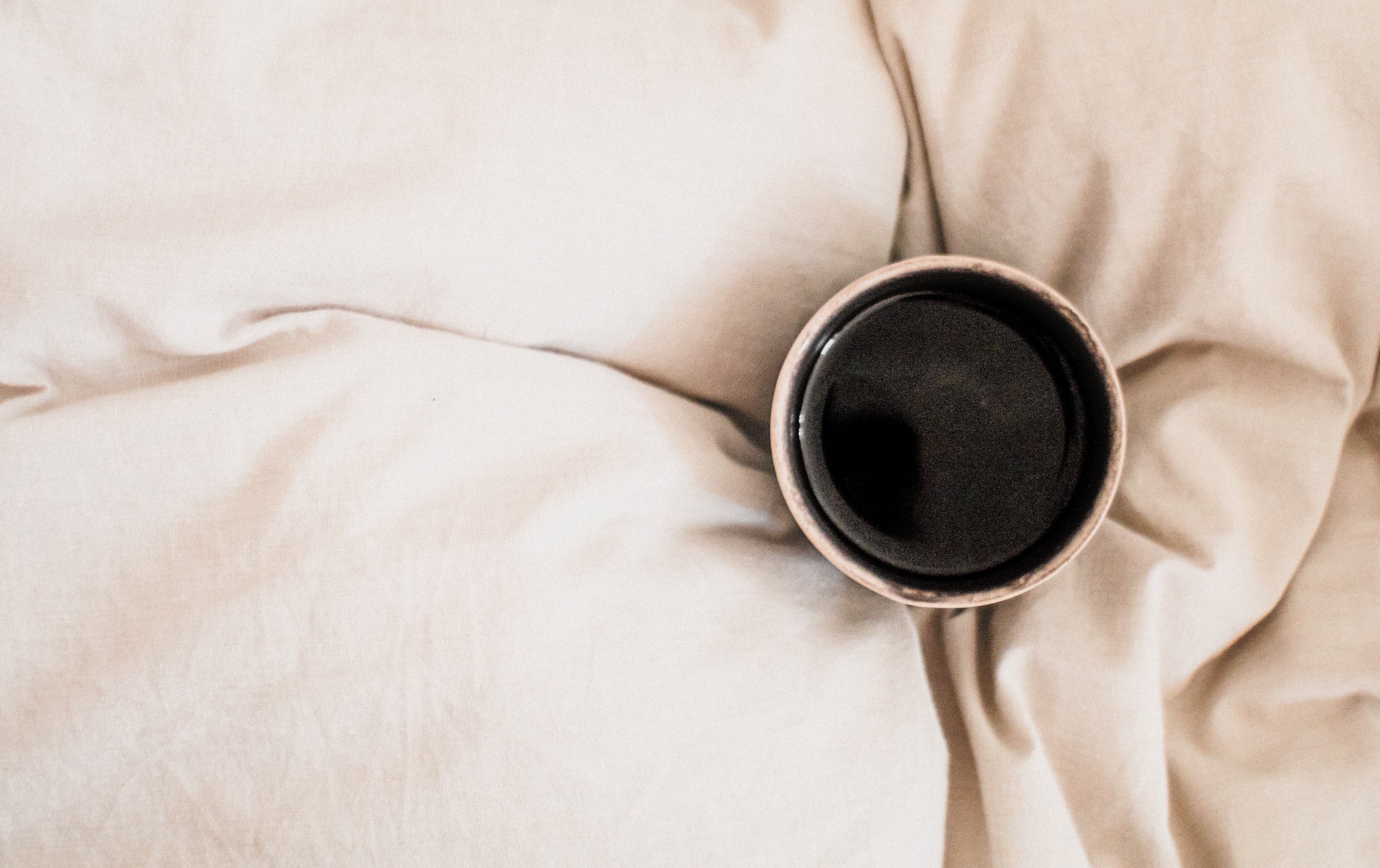 Kaffee Tasse auf Bettdecke