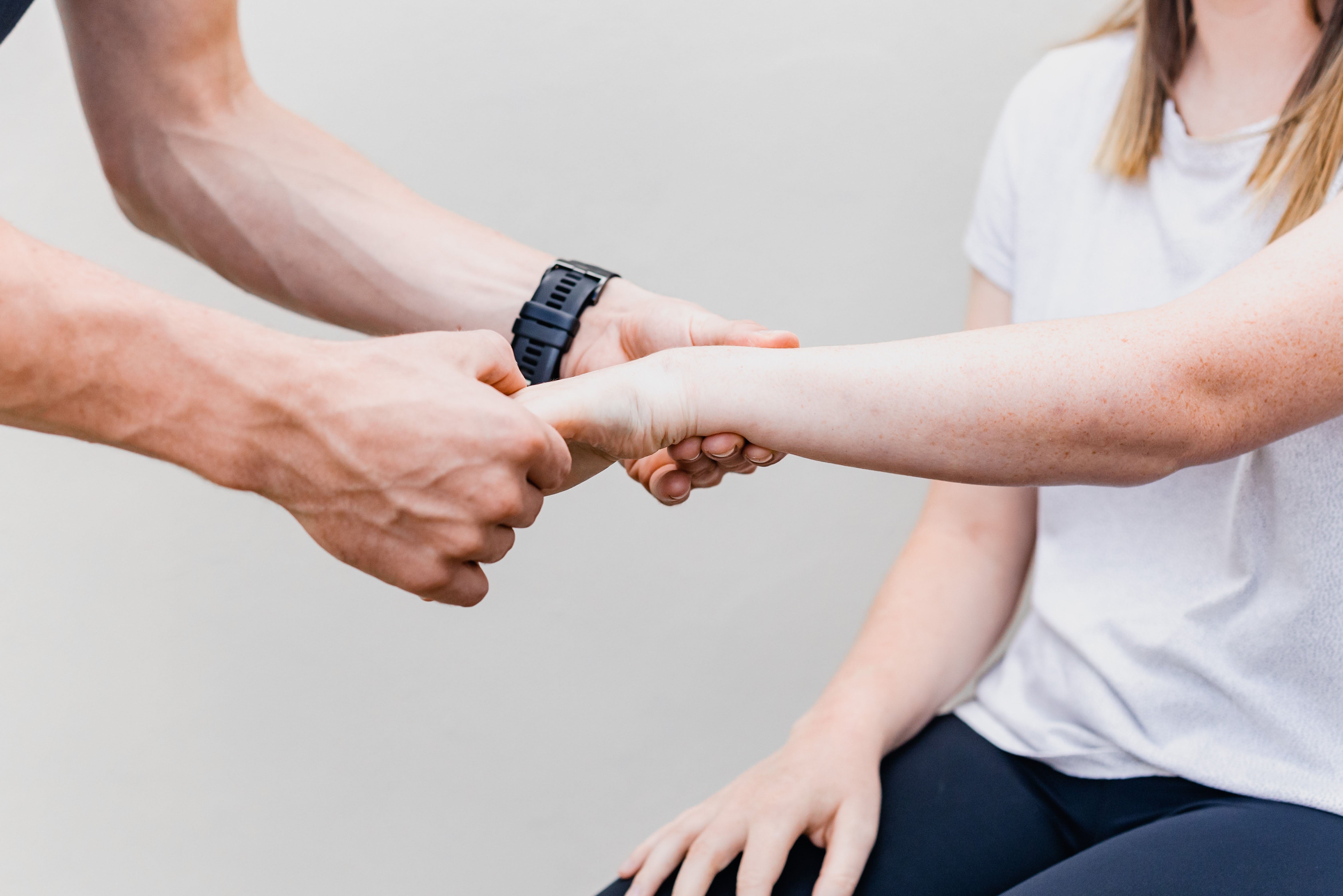 Mann hält Hand einer Frau bei einer Physiotherapie